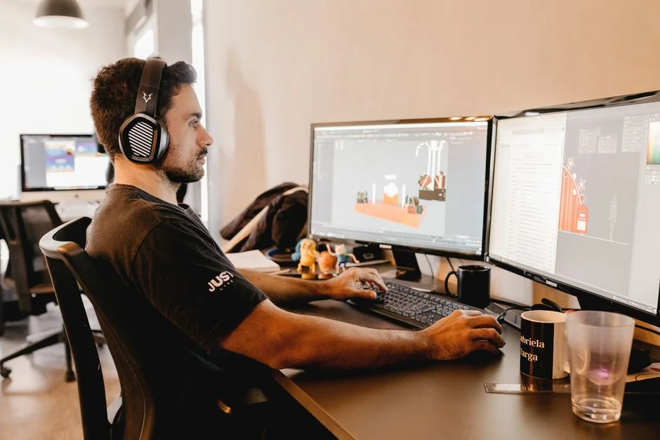 Close-up of an artist designing fashion sketches while seated at a desk indoors.