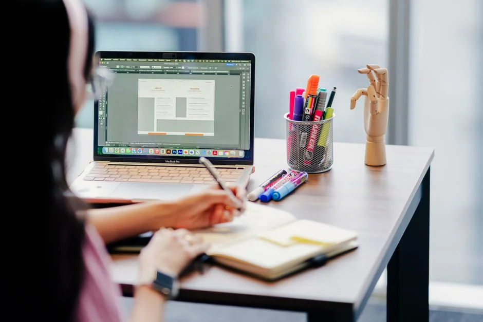 Un photographe travaillant dans un espace créatif avec un ordinateur portable et une tablette Wacom, concentré sur la retouche photo en intérieur.